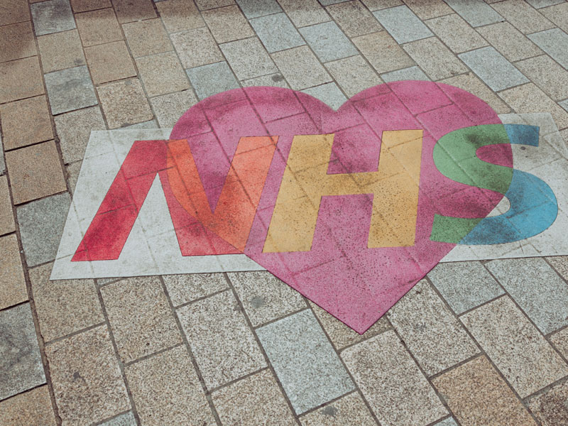 NHS mural on a pavement. Nicolas J Leclercq on Unsplash