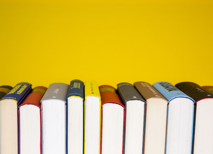 A row of books against a yellow background