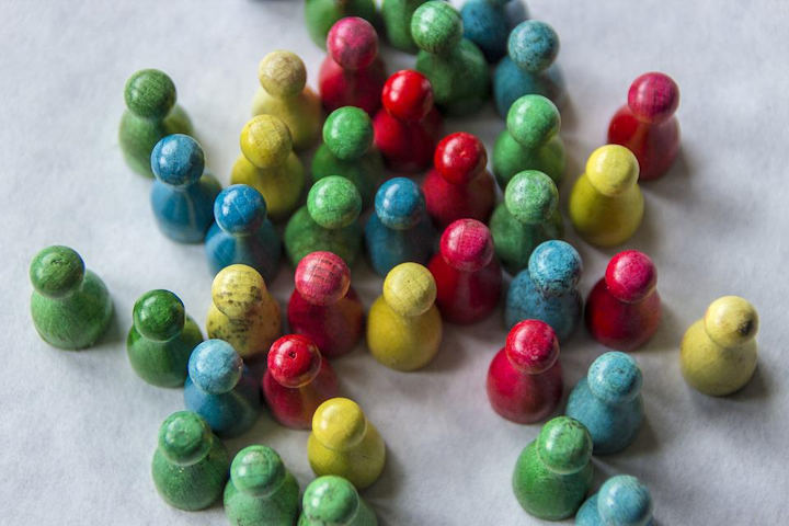 A group of wooden playing counters painted red, green, yellow and blue