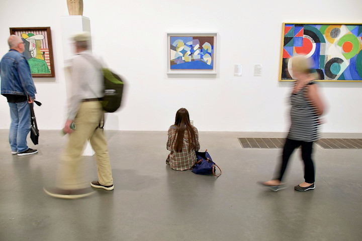 People view paintings in an art gallery