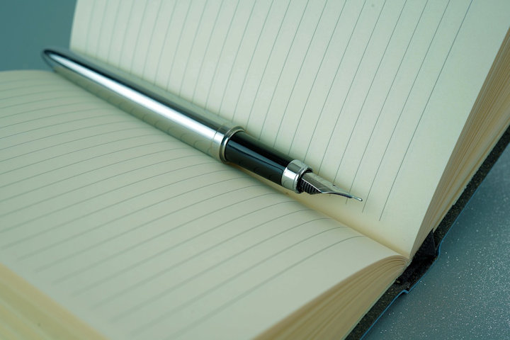 A lined notebook and pen