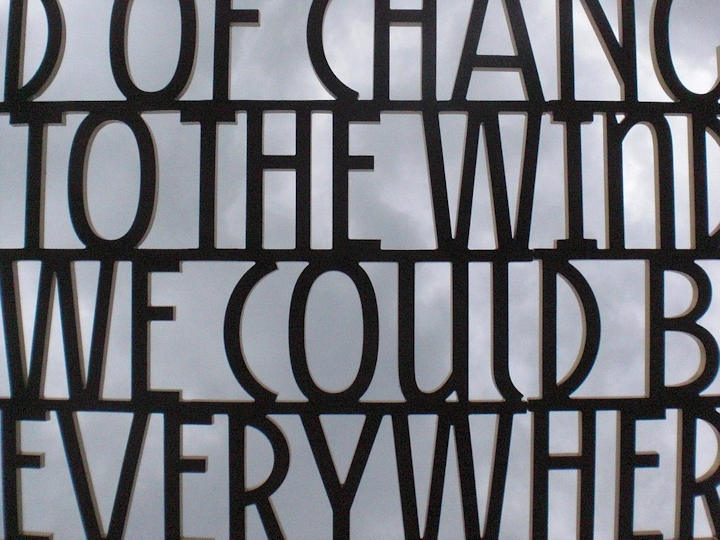 Metal letters silhouetted against the sky as part of a sculpture