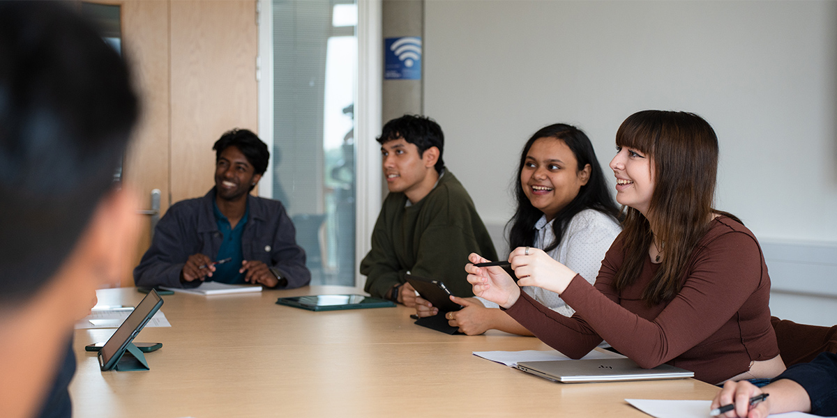 a group of students sitting around a table during a seminar in the department of computer science