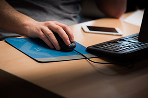 A keyboard, mouse and phone on a desk.