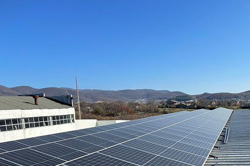 Solar panels outside an African village under a blue sky. Image from pixabay.com