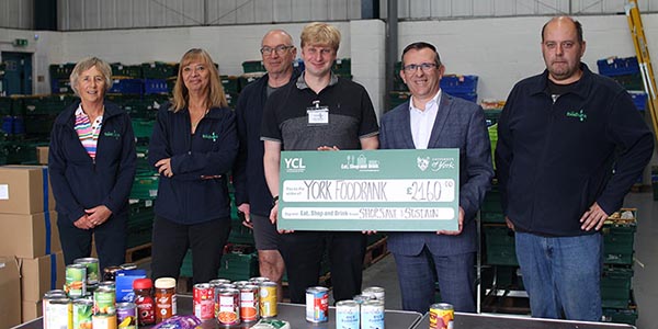 Arnaud Rustan, Senior Operations Manager for Catering and Retail, presents the team at York Foodbank with a £2160 donation