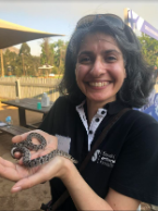 Dr Sara Padidar holding up a small Eggeater snake in her hands