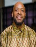Head shot photo of Dr. Wisdom Mdumiseni Dabulizwe Dlamini, wearing a patterned shirt